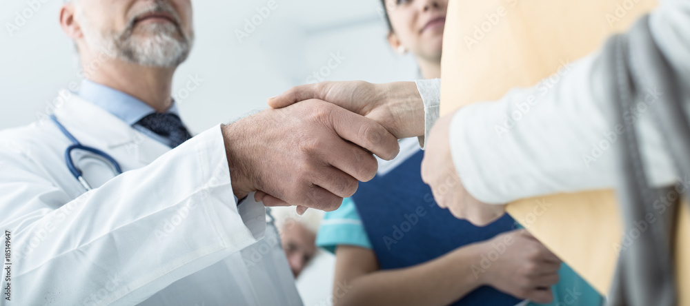 Doctor and patient giving an handshake Doctor and patient giving an handshake