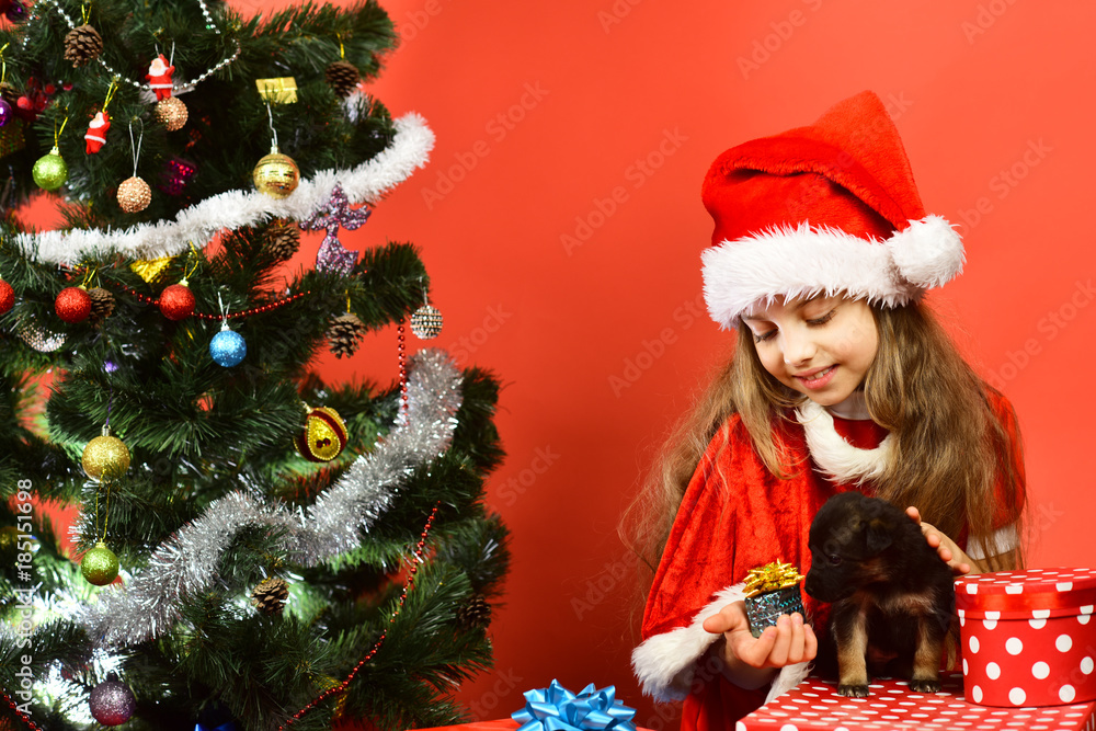 Kid with happy face unpacks gives presents on red background