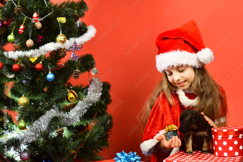 Kid with happy face unpacks gives presents on red background Kid with happy face unpacks gives presents on red background