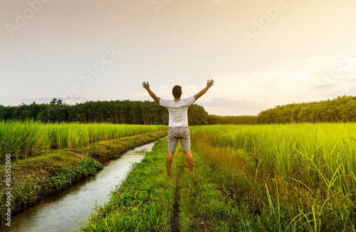 The man relax on rice field with sunrise or sunset