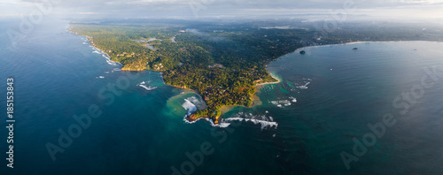 Aerial panorama of the cape of the town of Weligama with fisherman boats, beaches and waves breaking on the reef. Sri Lanka