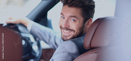Portrait of an handsome smiling business man driving his car