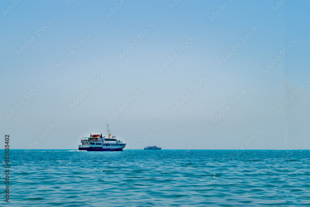 Pleasure boat and a yacht at sea on a sunny day