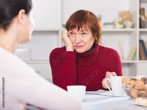 Portrait of sad mature woman talking with daughter