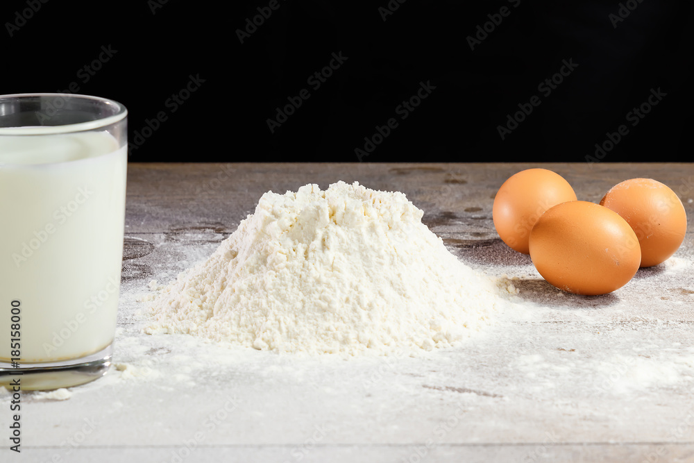 Flour and eggs, cooking dough. The recipe for cooking pizza, pasta, bread. House cooking from the chef. Dark background. Flour and eggs, cooking dough. The recipe for cooking pizza, pasta, bread. House cooking from the chef. Dark background.