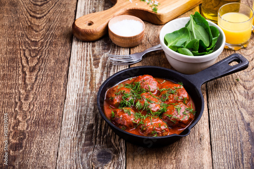 Beef meatballs in cast iron skillet on rustic wooden table