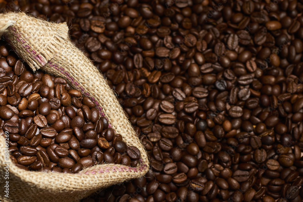 Fototapeta premium Studio Shot of Burlap Bag with Coffee over coffee beans