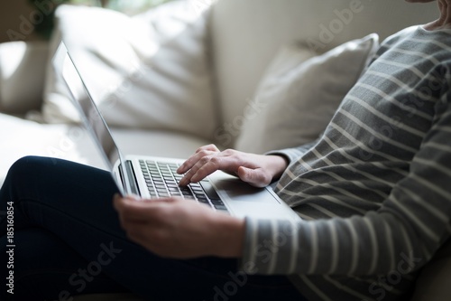 Mid-section of woman using laptop