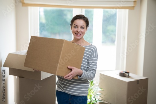 Woman carrying cardboard boxes in living room