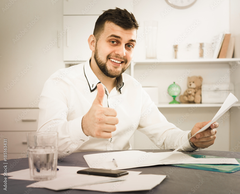 Young man is signing agreement papers