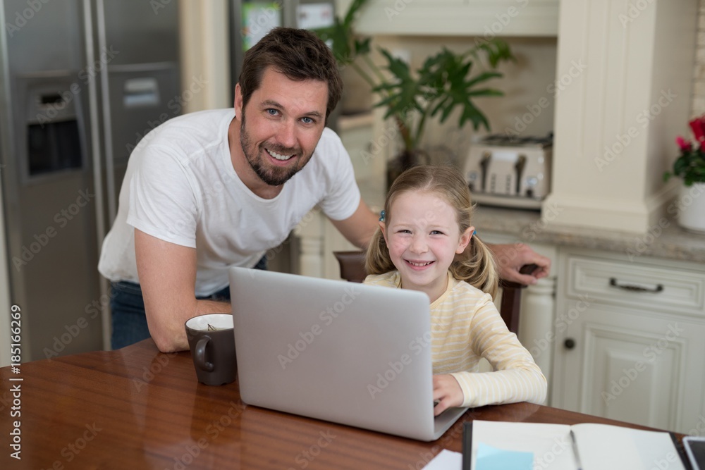 Father and daughter working on laptop at home Father and daughter working on laptop at home