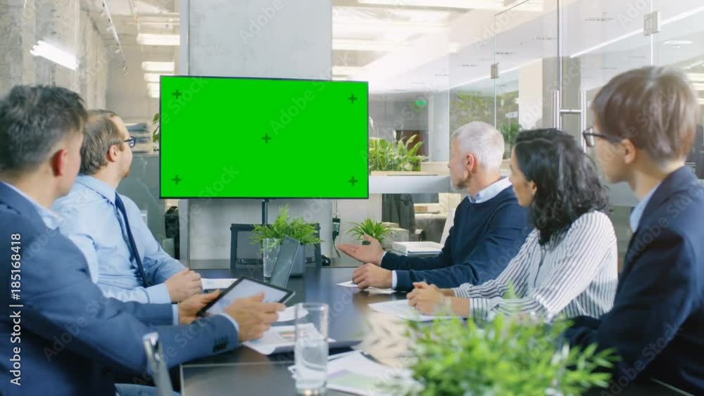 Diverse Group of Successful Business People in the Conference Room with  Green Screen Chroma Key TV on the Wall.  They Work on a Company's Growth, Share Charts and Statistics.  RED EPIC-W 8K Camera.
