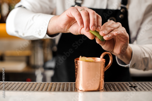 Bartender squeezing fresh lime juice into the cup © fesenko