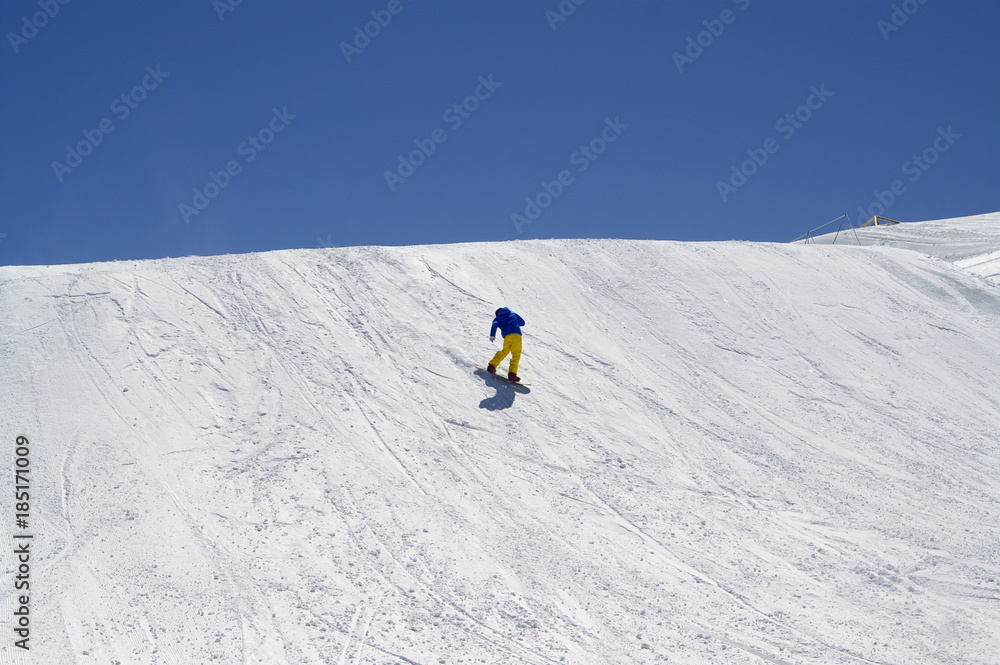 Snowboarder downhill in terrain park at ski resort