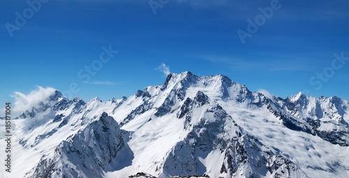 Panoramic view of snow covered mountain peaks and beautiful blue sky