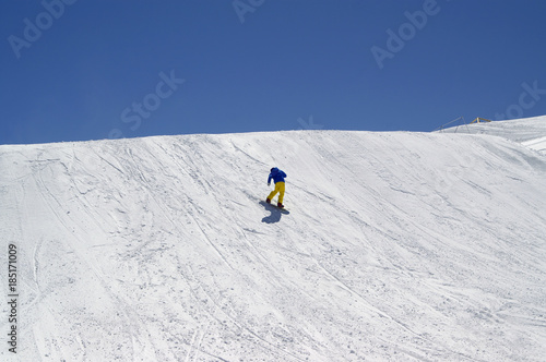 Snowboarder downhill in terrain park at ski resort