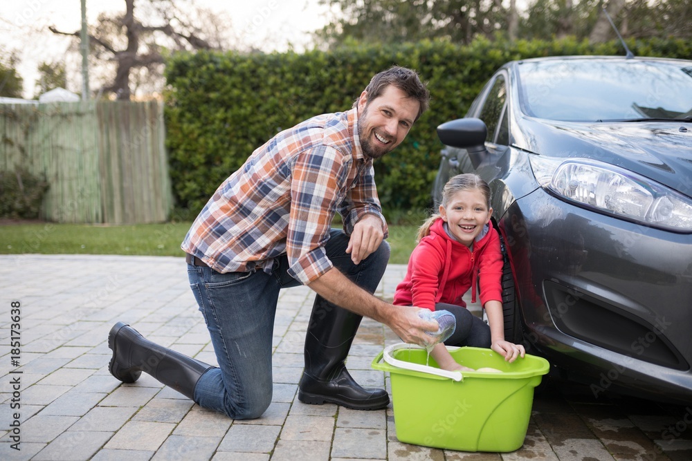 Teenage girl and father washing a car on a sunny day Teenage girl and father washing a car on a sunny day