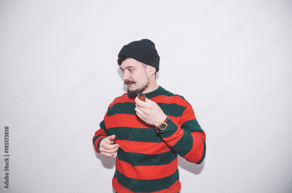 boy wearing bobble hat and smoking tobacco pipe boy wearing bobble hat and smoking tobacco pipe