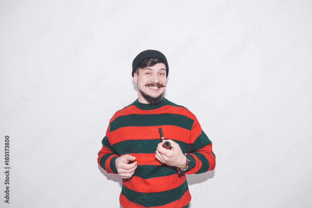 boy wearing bobble hat and smoking tobacco pipe boy wearing bobble hat and smoking tobacco pipe