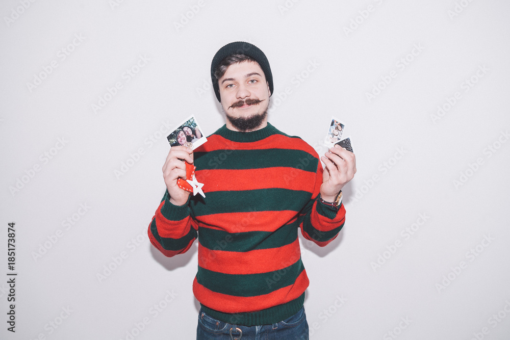 boy wearing bobble hat holds summer photos and christmas decoration boy wearing bobble hat holds summer photos and christmas decoration
