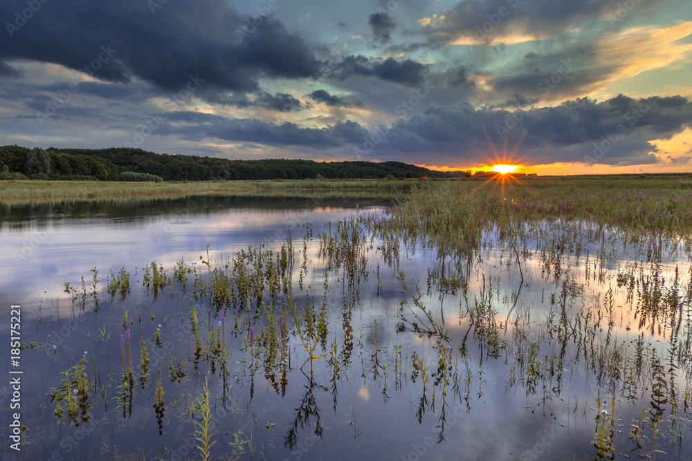 Dark river foreland landscape image with setting sun