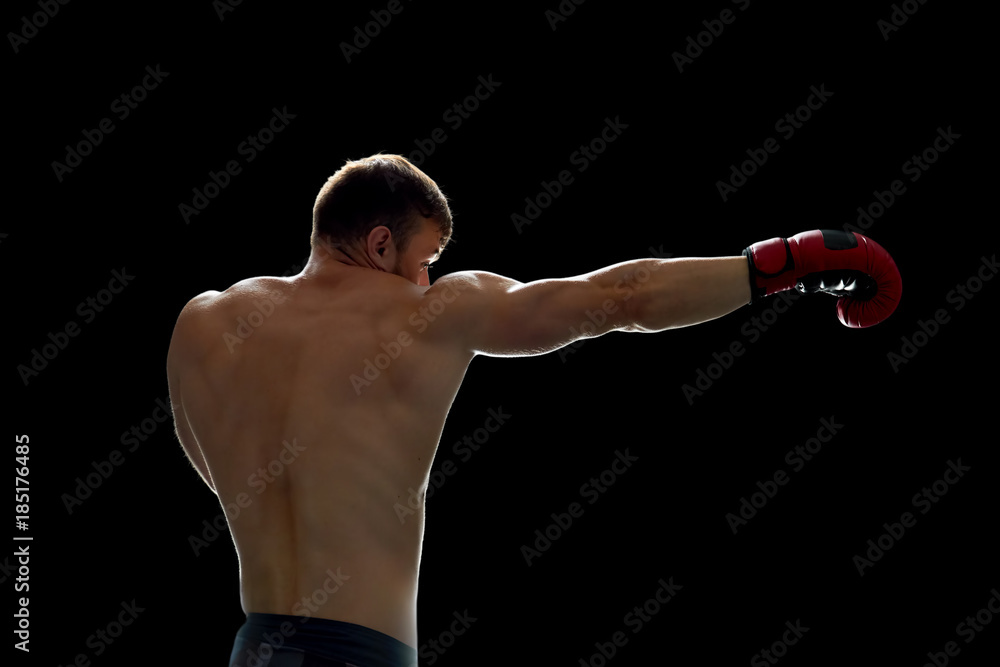 Fighter training on his own. Young man throwing kicks with boxing gloves on hands. Preparing for a match. Fighter training on his own. Young man throwing kicks with boxing gloves on hands. Preparing for a match.