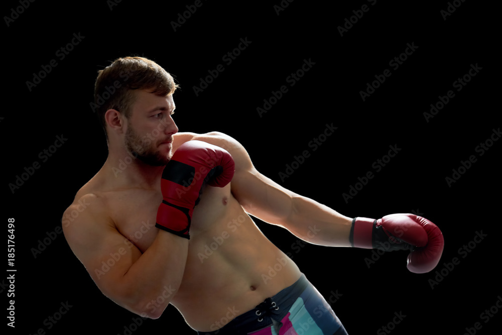 Sportsman on fighting training, dressed in boxing shorts and gloves. Improve your blows to the next level.