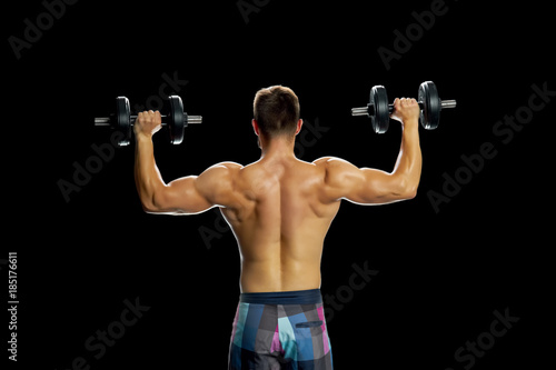 Athlete making exercises with dumbbells. Building perfect biceps by lifting weight. Strong and muscular body.