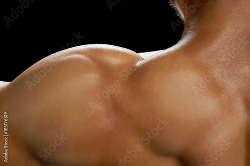 Close up on bicep muscles of a professional bodybuilder. Developing a bulky muscular body. Sport for looking fine.