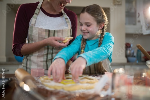 Mother and daughter preparing cookies in kitchen