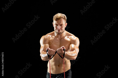 Athlete stretching a resistance band for developing strength. Safe and effective workout. Building strong muscles.
