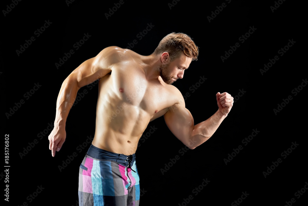 Athletic man posing and showing his muscles on black background. Sexy and beautiful body. Weightlifting workout goals. Athletic man posing and showing his muscles on black background. Sexy and beautiful body. Weightlifting workout goals.