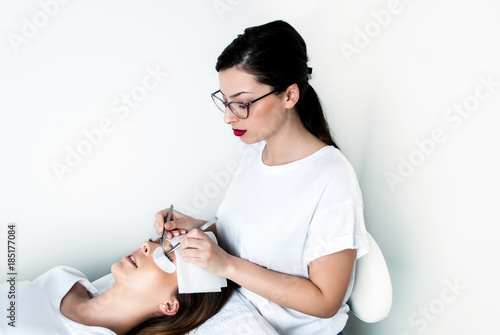 Slika na platnu Beautician working on upgrading silk eyelashes in a beauty studio