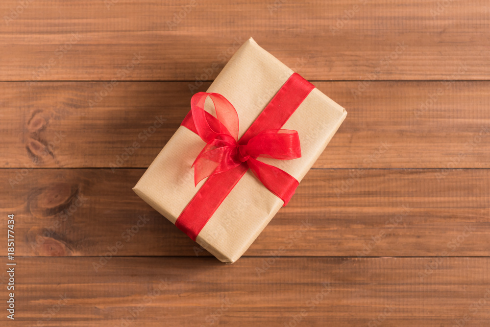 Gift box with red ribbon on wooden background. Gift box with red ribbon on wooden background.
