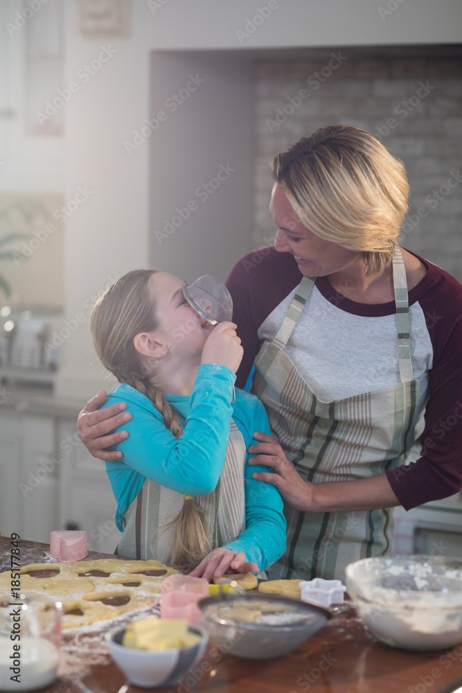 Mother and daughter having fun while preparing cookies in Mother and daughter having fun while preparing cookies in