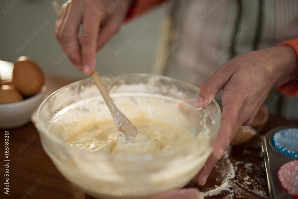 Woman mixing eggs and wheat flour in a bowl Woman mixing eggs and wheat flour in a bowl