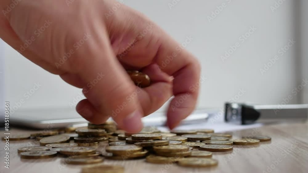 Man hand holding coin dollar on money coin stack arranged as a graph on wooden table. Hand of male or female finger step coins stack growing growth saving money. Business idea. Man hand holding coin dollar on money coin stack arranged as a graph on wooden table. Hand of male or female finger step coins stack growing growth saving money. Business idea.