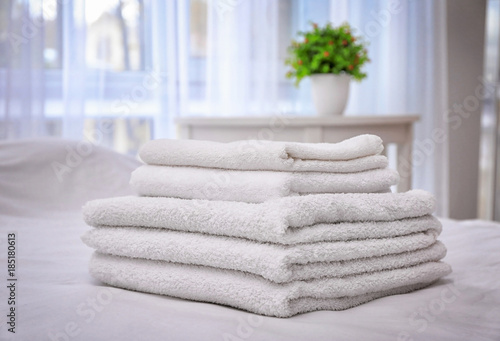 White bath towels on bed in hotel suite