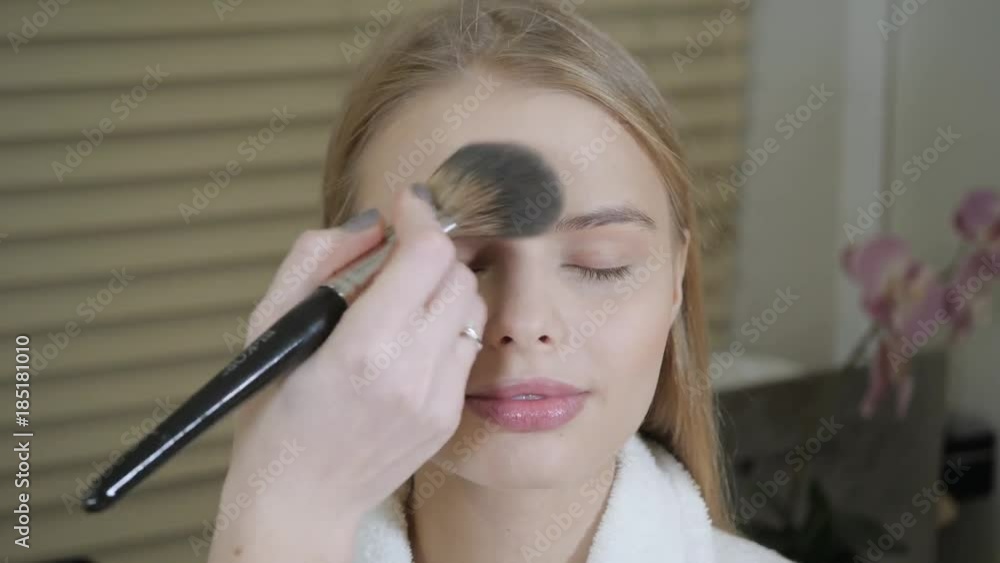 powder base brush. Makeup artist creating beautiful makeup for blondes model. Beauty and Spa centre concept powder base brush. Makeup artist creating beautiful makeup for blondes model. Beauty and Spa centre concept