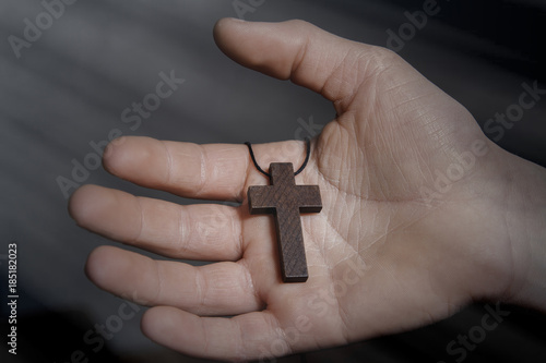 Wooden cross on praying children hand