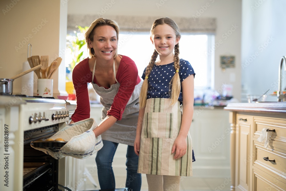 Obraz premium Mother and daughter preparing cup cake in kitchen