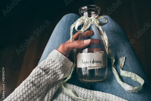 woman holding a bottle filled with hopes and dreams photo
