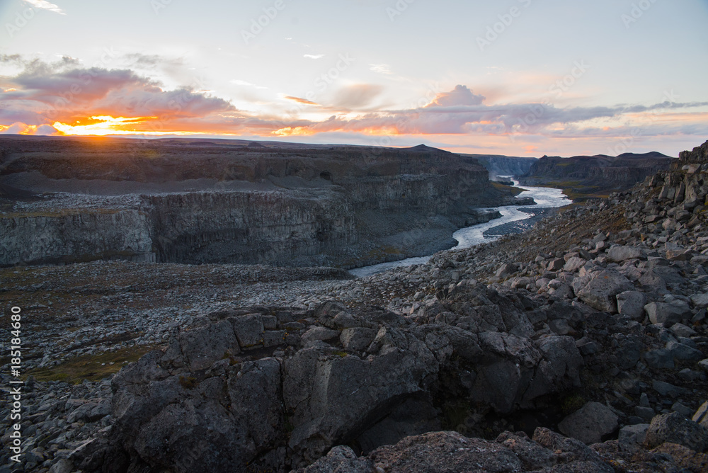A river flowing through a valley in Iceland during sunset. A river flowing through a valley in Iceland during sunset.