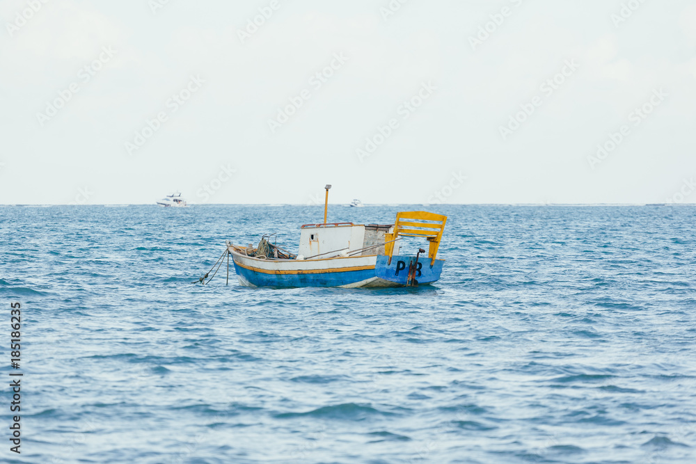 Obraz premium A little wooden boat floating in the sea