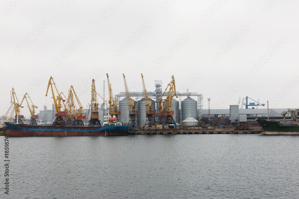 Seaport with ships and seagulls in cloudy and hazy weather