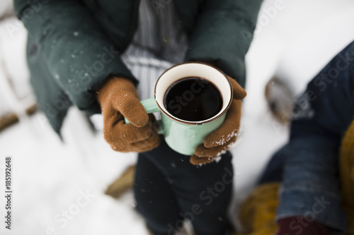 Young woman drinking mulled wine in snow photo