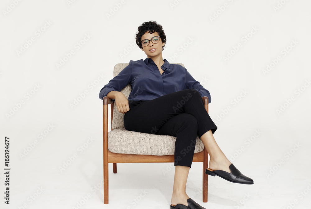 Portrait of a woman sitting on a chair in a white studio. Portrait of a woman sitting on a chair in a white studio.