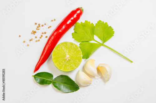 Composition with red chilli, garlic, lemon, Lime leaf, Shallot, Coriander seedschilli and spices isolated on white background. Top view. photo