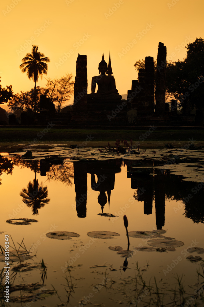 Temple ruins reflected in a pond at sunset at the  UNESCO World Heritage Site, Sukothai, Thailand.