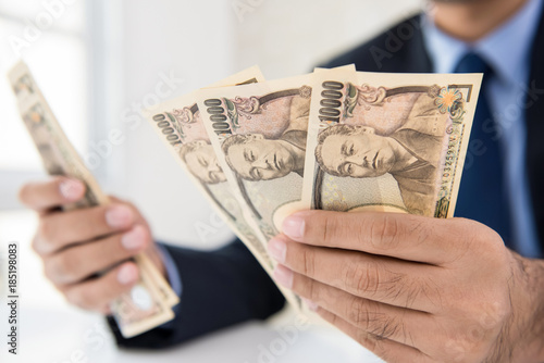 Businessman counting money Japanese yen banknotes